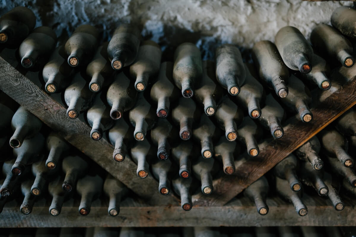 collection of dusty wine bottles in a cellar